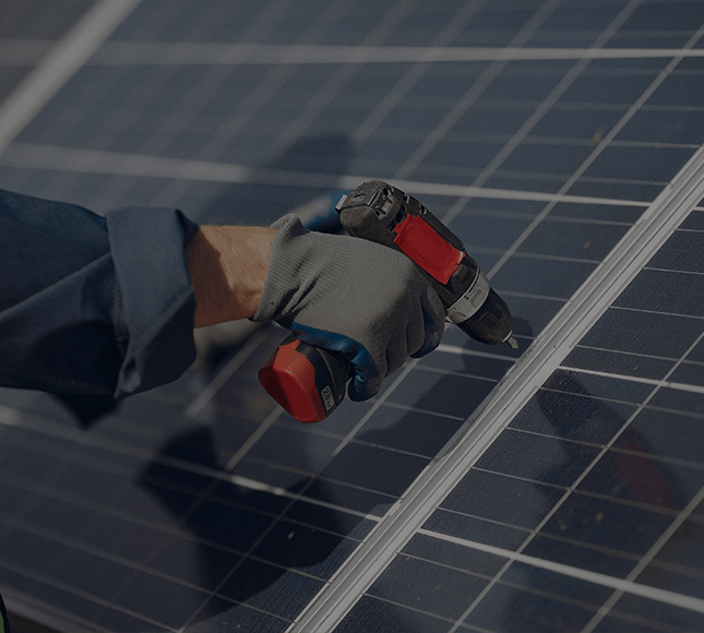 zu sehen ist eine Hand mit Akkuschrauber, die ein Photovoltaikpanel festschraubt